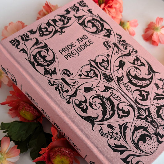Pink book titled 'Pride and Prejudice' with decorative cover on a floral background